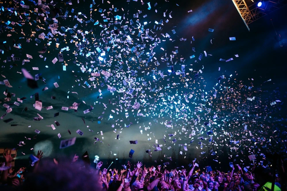 A crowd at a live event under falling confetti