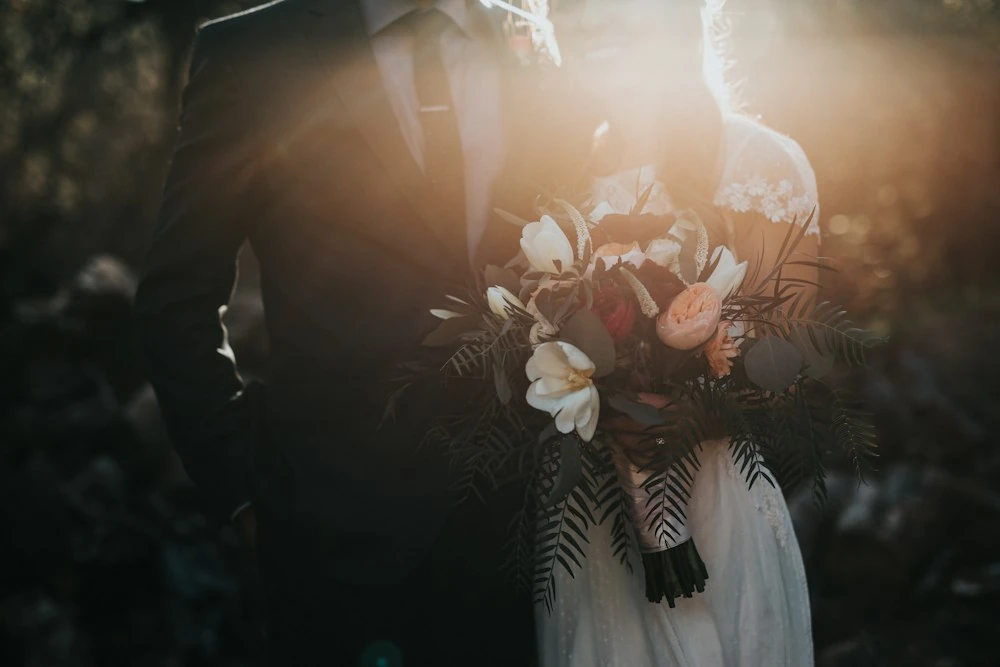 A wedding bouquet held in warm light